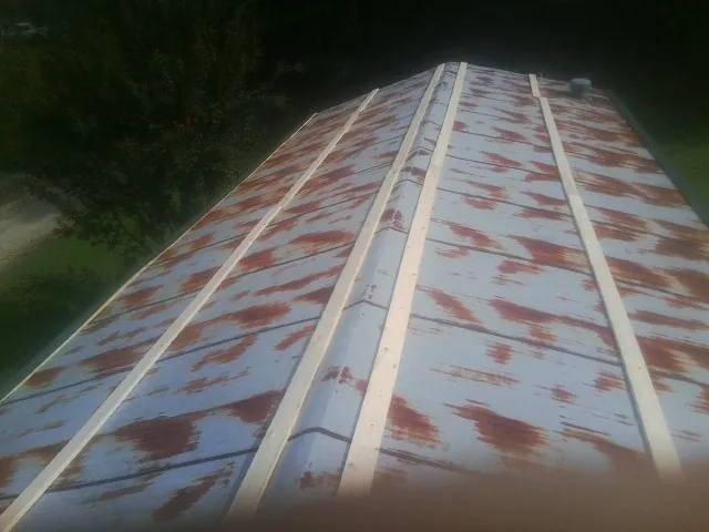 Rusted metal roof panels with new wood purlins before replacement — Storm Damage Roof Repair in Woodsboro by Roofing Brothers