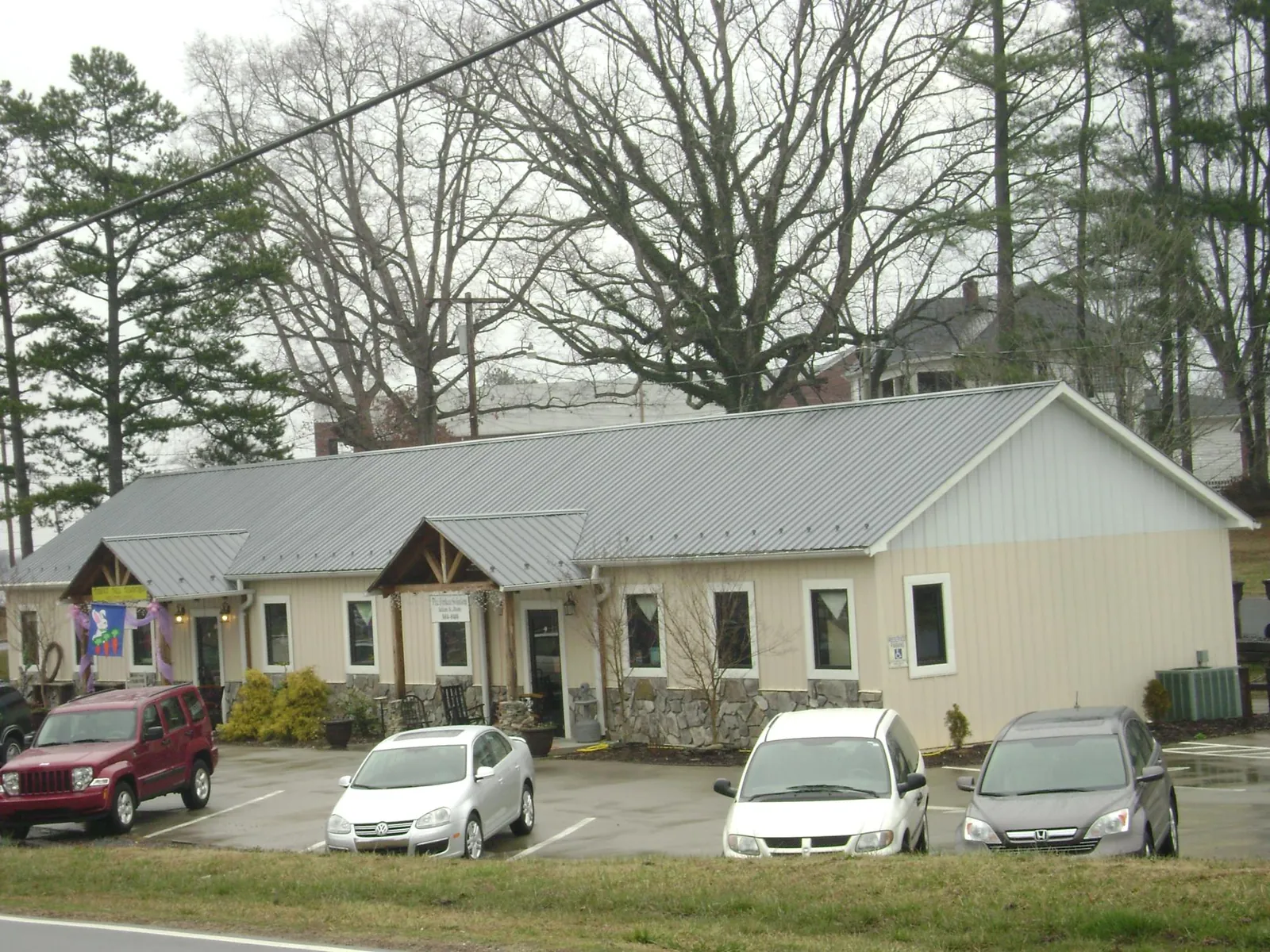 Gray metal roof with timber entry brackets on a small commercial building in Woodsboro